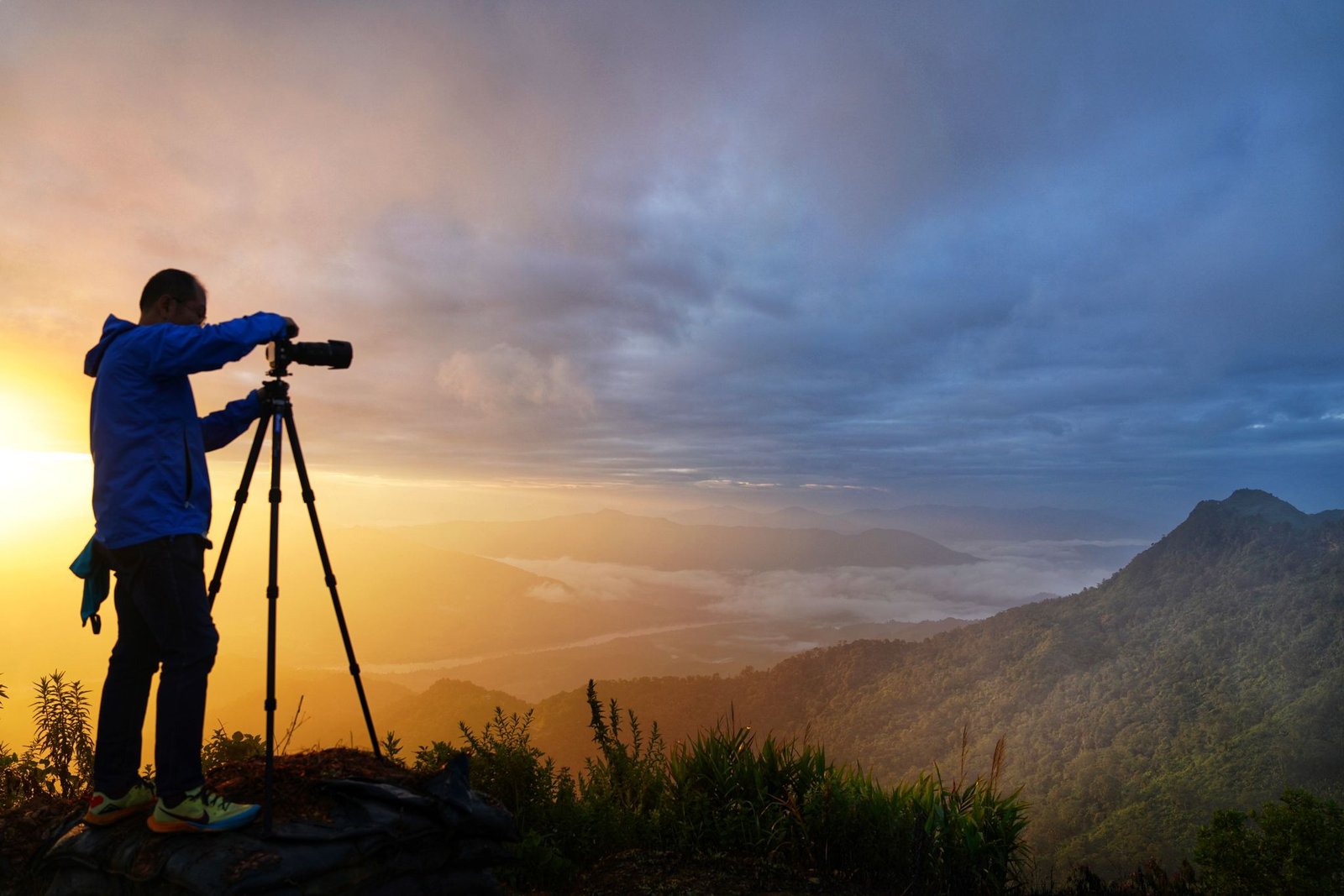 Michael Choong photographing on a mountain ridge at sunrise